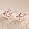 Tiny Crystal Star Stud Earrings in Rose Gold on Beige Fabric