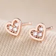 Tiny Crystal Star Stud Earrings in Rose Gold on Beige Fabric