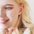 Blonde Model Wearing Tiny Crystal Star Stud Earrings in Rose Gold