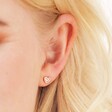 Close Up of Model Wearing Tiny Crystal Star Stud Earrings in Rose Gold