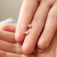 Model Holding Tiny Crystal Star Stud Earrings in Rose Gold Between Fingers