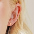 Close Up of Model Wearing Tiny Star Stud Earrings in Gold