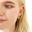 Blonde Model Wearing Wide Rainbow Crystal Hoop Earrings in Gold