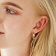 Blonde Model Wearing Wide Rainbow Crystal Hoop Earrings in Gold with Other Earrings