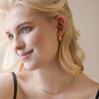 Blonde Model Wearing Herringbone Chain Necklace in Gold with Black Top
