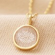 Close Up of Gold Personalised Clear Resin Birth Flower Pendant Necklace on Beige Fabric