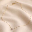 Semi-Precious Grey Labradorite Stone Teardrop Pendant Necklace in Gold on Rippled Beige Fabric