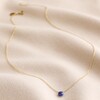 Semi-Precious Lapis Lazuli Stone Teardrop Pendant Necklace in Gold on Rippled Beige Fabric