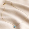 Semi-Precious Turquoise Stone Teardrop Pendant Necklace in Gold on Rippled Beige Fabric