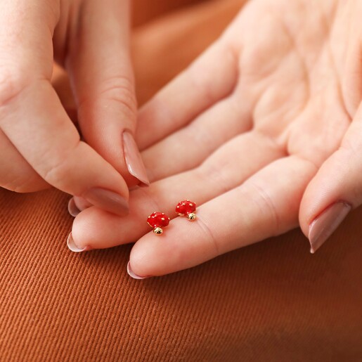 Model Holding Mushroom Earrings Model Holding Red Enamel Mushroom Stud Earrings in Gold