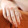 Model Wearing Twisted Rope Ring in Gold with Hand on Knee