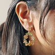 Model Wearing Crystal Flower and Enamel Bee Drop Earrings Close Up with Cream Background