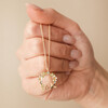 Model Holding Crystal Flower and Enamel Bee Pendant Necklace in Gold