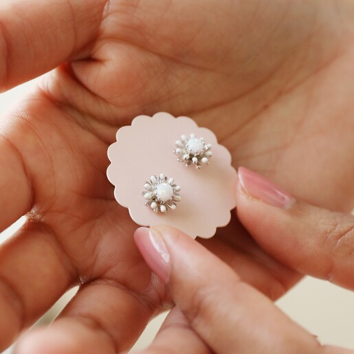 Model Holding Opal and Enamel Stud Earrings in Silver in Packaging