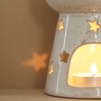 Ceramic Starry Wax Melt Burner with Tealight Inside in Dimmed Room with Stars Reflecting on Wall
