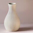 Empty Rounded Neutral Ceramic Vase against Purple Background
