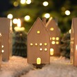 Rustic Ceramic House LED Decoration Surrounded by Others in a Wintry Scene