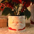 Small Ceramic Father Christmas Planter Filled With a Red Poinsettia