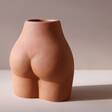 Back of Small Porcelain Body Vase on Beige Background