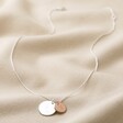 Silver Personalised Family Constellation Disc Charm Necklace With Large Silver Charm and Small Rose Gold Charm Full Length on Beige Fabric