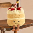 Jellycat Amuseable Birthday Cake Soft Toy Sitting on Wooden Chair
