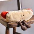 Jellycat Amuseable Hot Dog Soft Toy Sitting on Wooden Chair