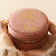 Pink Personalised Birth Flower Velvet Round Travel Jewellery Case in Front of Neutral Background