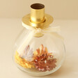 Dried Flower Filled Glass Candlestick Holder in Gold on Neutral Background