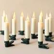 Set of 10 Cream Small LED Wick Candles Turned on in Lit Room Against Neutral Background