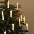 Set of 10 Cream Small LED Wick Candles on Christmas Tree in Dim Lit Room