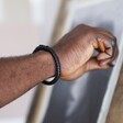 Man Wearing Men's Personalised Black Clasp Leather Bracelet from Photo Gift Box while Drawing
