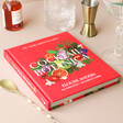 Cocktail Botanica Book on Pink Surface Surrounded by Drink Making Equipment
