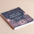 Blue and Pink Front Cover of How to Manifest Book on Cream Background