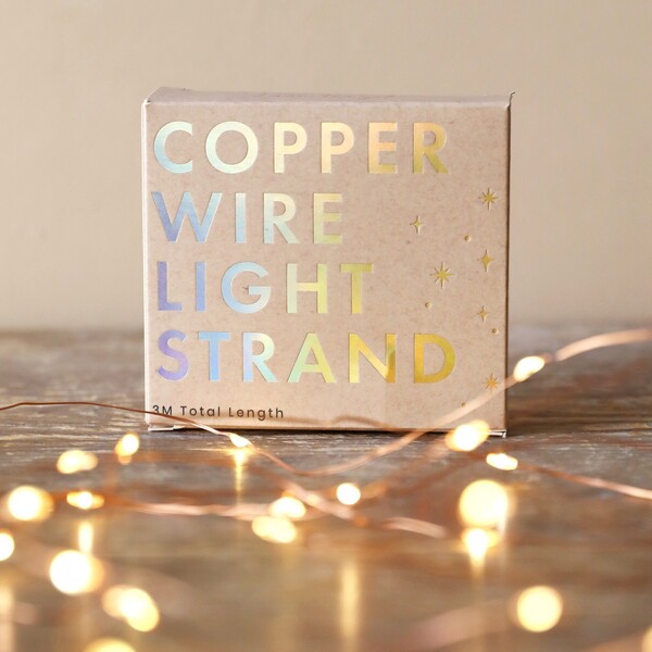 30 Battery Powered LED Copper Wire String Lights sat on top of wooden counter with 