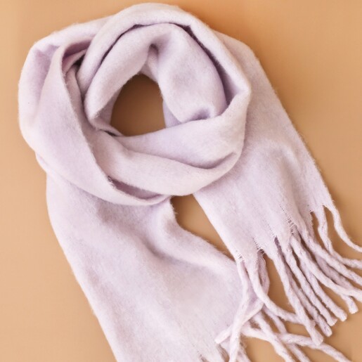 Pastel Lilac Winter Scarf Arranged on Top of Orange Background