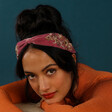 Model Wearing Powder Embellished Floral Headband in Purple with Navy Background