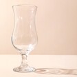 Empty Piña Colada Cocktail Glass with Shadow Facing Right on Beige Background