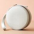 Front of Mini Round Travel Jewellery Case in Grey on Pink Background