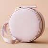 Front of Mini Round Travel Jewellery Case in Lilac Pink on Peach Background