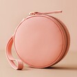 Front of Mini Round Travel Jewellery Case in Pink on Peach Background