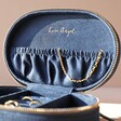 Sun and Moon Embroidered Oval Jewellery Case in Navy Open with Jewellery Inside on a Natural Coloured Backdrop