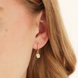 Model Wearing Beaded Daisy Charm Huggie Hoop Earrings in Gold