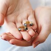 Black Cloisonné Hoop Earrings in Gold in Model's Hands