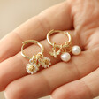 Model Holding Daisy, Pearl and Bee Charm Hoop Earrings in Gold