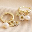 Daisy, Pearl and Bee Charm Hoop Earrings in Gold on Beige Fabric
