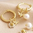 Charm Combinations on the Daisy, Pearl and Bee Charm Hoop Earrings in Gold on Fabric