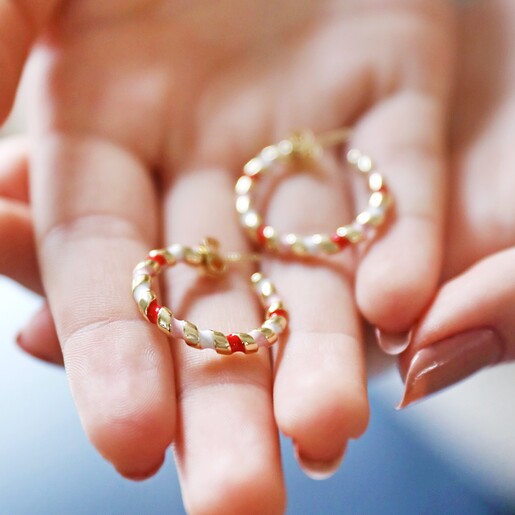 Model Holding Red, White and Pink Twisted Enamel Hoop Earrings in Gold