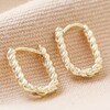 Rope Oval Huggie Hoop Earrings in Gold on Beige Fabric