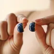 Model Holding Small Navy Resin Hoop Earrings in Gold 