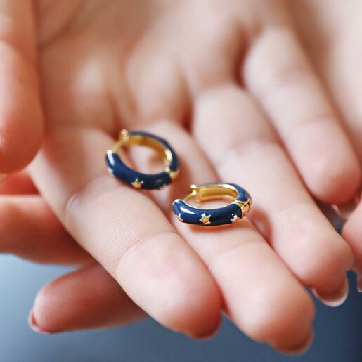 Starry Navy Enamel Hoop Earrings Being Held by Model